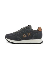 Sneaker in suede grigia con una suola bianca, presenta un accento in pelle marrone sul tallone e un design con forme geometriche sul lato.