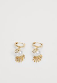 Boucles d'oreilles en or avec un grand pendentif en perle blanche, ornées d'accentuations en forme de feuille et de petits cristaux transparents pendent en dessous.