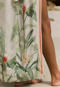 Kukallinen kimono, jossa on vihreitä lehtiä ja punaruskeita kukkia, kevyttä kangasta, sivurei'ät ja kontrasteraava persikkakuvio.