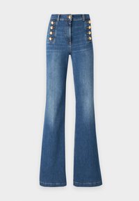 Ψηλόμεσο flared τζιν σε μεσαίο μπλε ντένιμ, με χρυσά κουμπιά στο πλάι και λεία υφή.