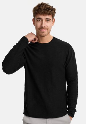 Zwarte langekous T-shirt van een gladde, lichte stof met een ronde hals, aansluitende mouwen en een subtiele textuur.