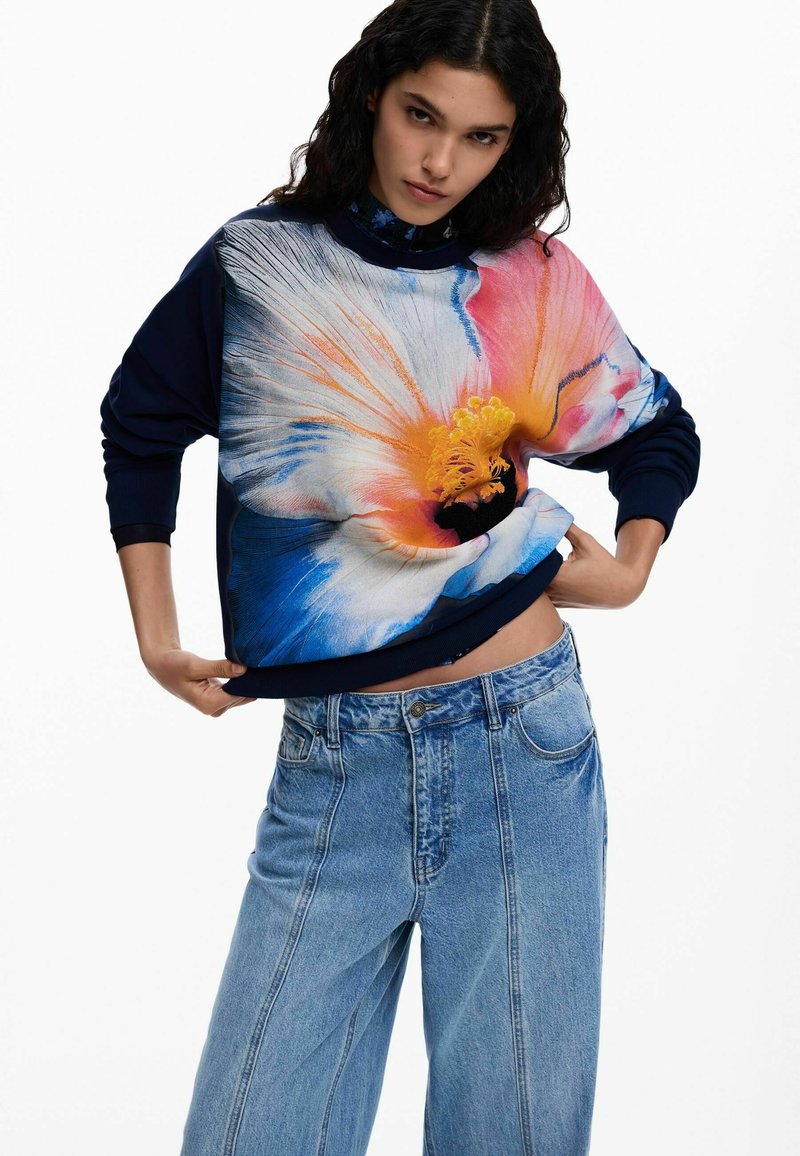 Hanorac bleumarin cu imprimeu mare și colorat de flori, având accente portocalii, roz și albastre. Croială lejeră cu manșete și tiv striate.