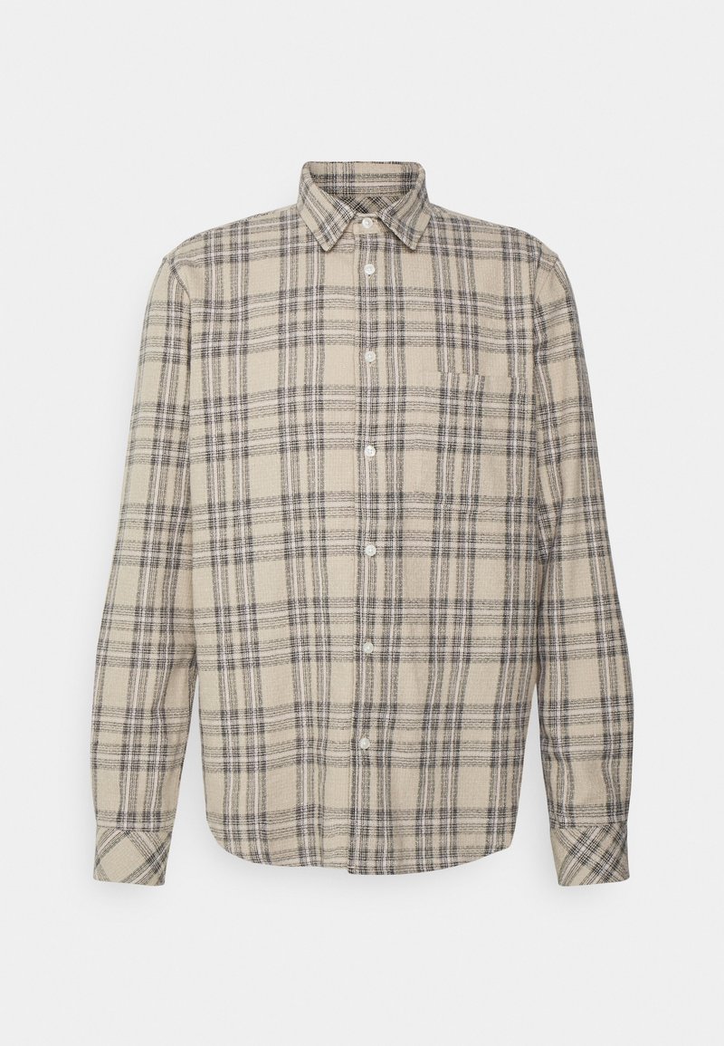 Beige flanelipaita, jossa on musta ja harmaa ruutukuosi, pitkät hihat, napitettava kaulus ja yksi rintatasku.