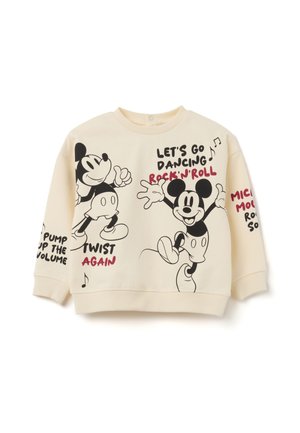 Sweat-shirt crème avec des illustrations de Mickey Mouse dansant et des phrases textuelles telles que « Allons danser », « Rock’n’Roll » et « Re-twist ».