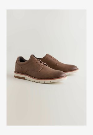 Braune Lederschuhe mit glatter Oberfläche, abgerundeter Zehenpartie, Schnürdesign und kontrastierender weißer Gummisohle mit leichtem Beige-Akzent.