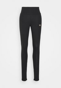 Černé legíny s vysokým pasem, hladký materiál, malá zlatá logo na levé straně a zipy na kotnících.