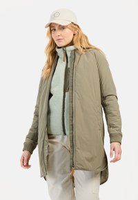Lichtgewicht olijfgroene lange jas met ritssluiting, geribde manchetten en zijzakken, gelaagd over een textuur mintgroene fleece top. Beige pet.