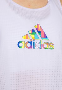 Weißes sportliches Tanktop mit strukturiertem Muster und einem mehrfarbigen grafischen "adidas"-Logo aus kräftigen, geometrischen Formen.