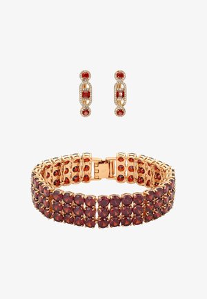 Bransoletka w kolorze złotym oraz pasujące kolczyki z czerwonymi kamieniami ozdobnymi. Bransoletka ma ogniwisty wzór; kolczyki są wiszące o geometrycznym kształcie.