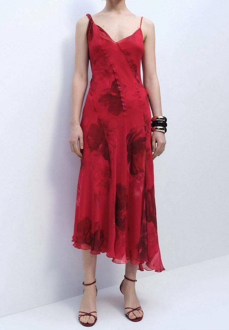 Robe fleurie rouge à la silhouette fluide, avec des bretelles spaghetti réglables et un ourlet arrivant au genou, confectionnée dans un tissu léger.