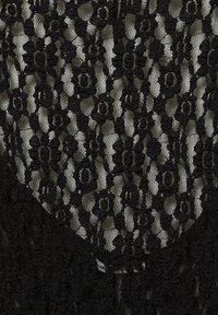 Tessuto di pizzo nero con motivi floreali, caratterizzato da una texture trasparente. Il design include motivi sovrapposti che creano un effetto a strati.