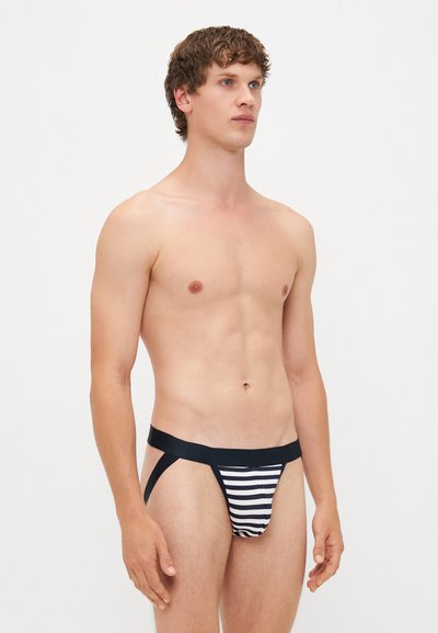 Schwarz-weiße gestreifte Slips mit einem breiten elastischen Bund. Das Material wirkt weich mit einer glatten Textur und minimalem Schnitt.