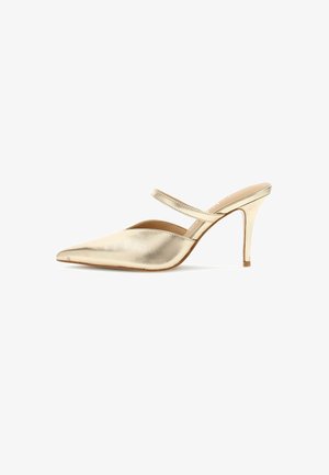 Glänzender goldener High-Heeled Mule mit spitzer Zehe und dünnem Riemen über dem Spann vor weißem Hintergrund.