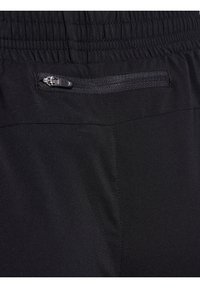 Pantaloni sportivi neri con tessuto testurizzato, vita elastica e una piccola tasca con zip sul retro. Visibili dettagli delle cuciture.