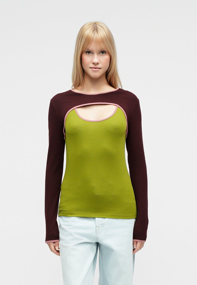 Μπλούζα με μακριά μανίκια που διαθέτει πράσινο κορμό, μαροον μανίκια και μοναδική λεπτομέρεια λαιμού με κόψιμο και αντίθετη ροζ επένδυση.