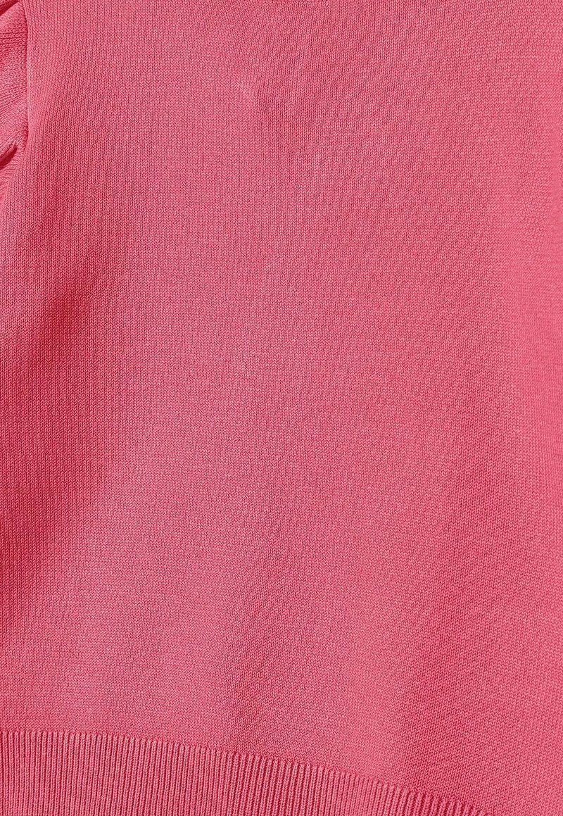 Suéter de punto en tejido suave y de peso medio. Presenta un color rosa vibrante con una textura suave y dobladillo acanalado. Diseño sencillo, sin patrones.