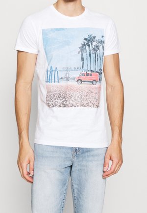 White cotton T-shirt featuring a photographic print of a red van at Imperial Beach, with palm trees and a blue sky in the background.