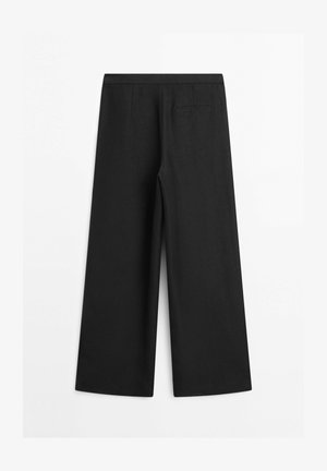 Schwarze Hosen mit weitem Bein, hohem Bund und einer einzigen Gesäßtasche mit Schlitz, liegend flach auf weißem Hintergrund präsentiert.