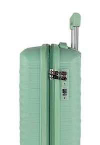 Maleta rígida color verde menta, con diseño acanalado, doble cremallera y cerradura con combinación integrada, con un asa metálica retráctil.