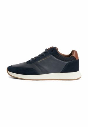Herren Sneaker in Marineblau und Braun mit weißer Sohle, Mesh- und Wildlederdetails, Schnürsenkeln und „Tommy Hilfiger“-Logo an der Seite.