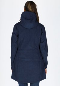 Navy blue hooded jacket with a cinched waist, long sleeves, and a straight cut, made from a textured, durable fabric. Features a back vent.