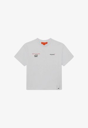 Biała koszulka z krótkim rękawem i okrągłym dekoltem z logo McLaren oraz małym tekstem na piersi i małą metką z logo na dolnym brzegu.