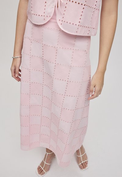 Lys pink to-delt outfit med en vest og en lang nederdel med et rutemønster og broderede detaljer. Stoffet ser struktureret og glat ud.