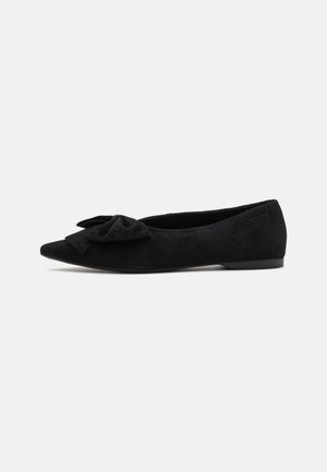 Black suede pointed-toe flats featuring a decorative bow on the front and a low heel. Smooth texture with a minimalist design.