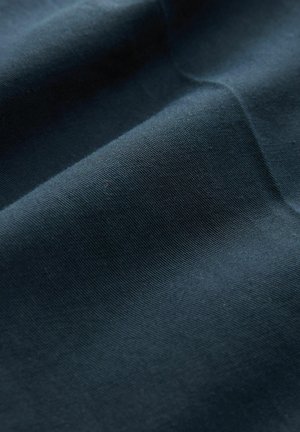 Tessuto blu scuro con una consistenza liscia, caratterizzato da leggere pieghe e grinze, che illustrano la morbidezza e la capacità di adattamento del materiale.