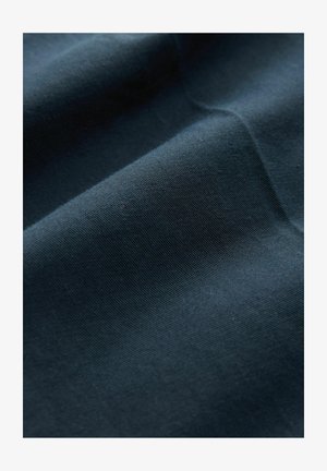 Tessuto blu scuro con una consistenza liscia, caratterizzato da leggere pieghe e grinze, che illustrano la morbidezza e la capacità di adattamento del materiale.