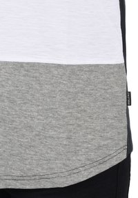 Camiseta de hombre en blanco, gris claro y gris oscuro. Presenta un dobladillo redondeado y costuras en contraste. Etiqueta en el lateral con el logo "BLEND".