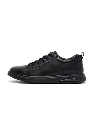 Zwarte lage sneaker met vetersluiting, gevoerde zool en zichtbaar luchtkussen in de hiel, vanaf de zijkant op een witte achtergrond.