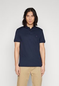 Middendonkblauwe poloshirt van katoen, met een drie-knoopsluiting, korte mouwen en een klein logo op de borst.