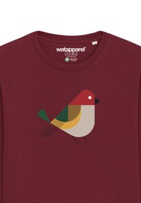Bordeauxrood katoenen t-shirt met een afbeelding van een gestileerde vogel in rood, bruin, groen en geel, vergezeld van geometrische vormen en lijnen.