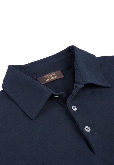 Marineblauwe poloshirt gemaakt van katoenmix, met een klassieke kraag, drie knopen en een label met de tekst "Slowear icecotton."