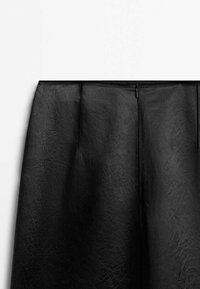 Black leather skirt featuring a smooth texture, a fitted waistband with a zipper closure, and subtle pleating at the front.