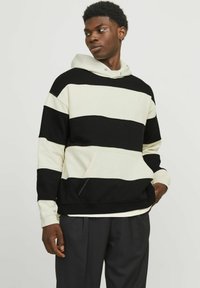 Sweat-shirt à capuche avec des rayures horizontales noires et blanches, en tissu doux, doté d'une poche frontale et de poignets côtelés.