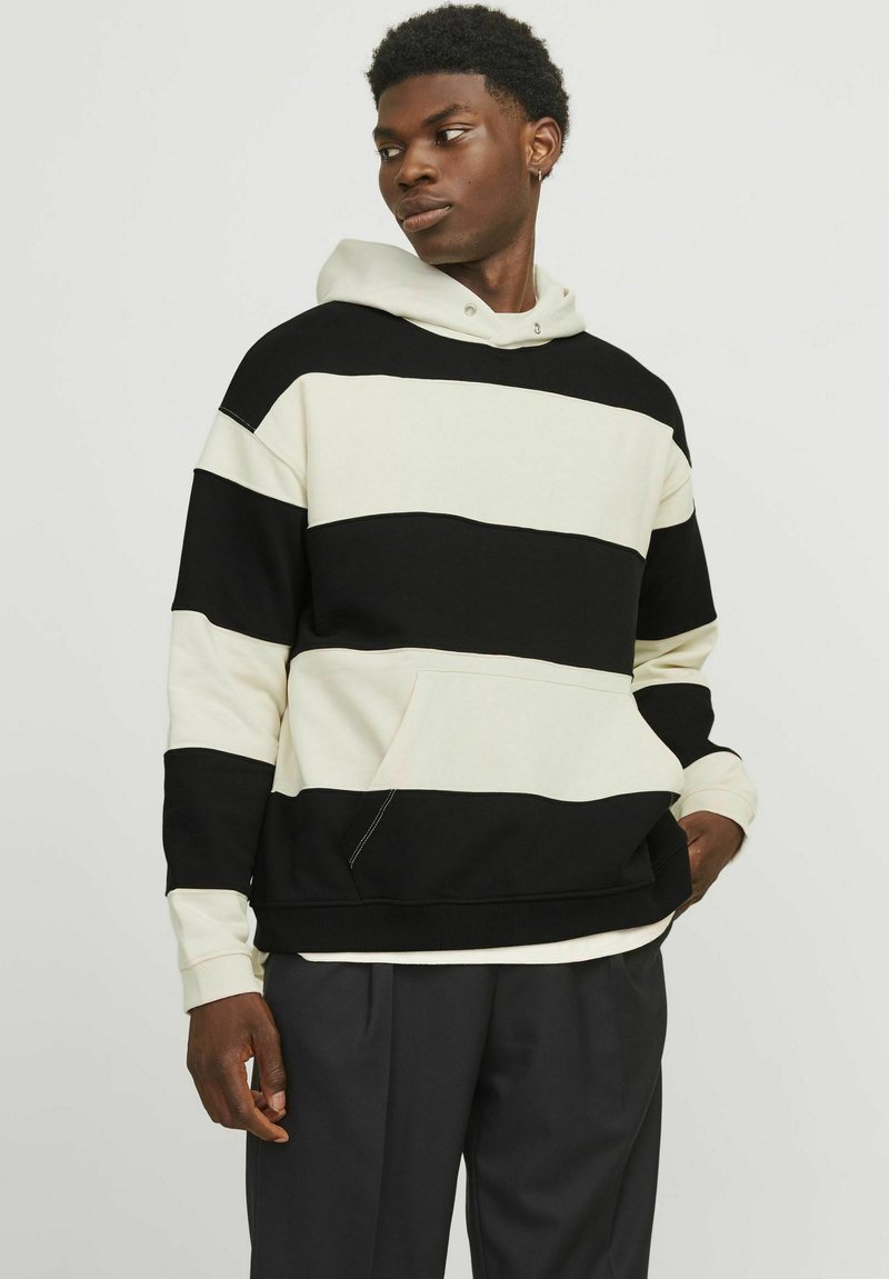 Sweat-shirt à capuche avec des rayures horizontales noires et blanches, en tissu doux, doté d'une poche frontale et de poignets côtelés.