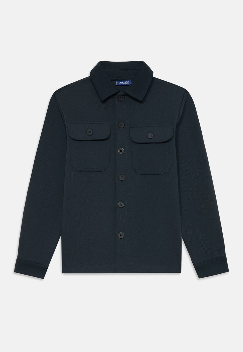 Camicia a maniche lunghe di un blu scuro, con colletto, chiusura a bottoni e due tasche sul petto. Realizzata in un tessuto morbido e testurizzato con dettagli di cucitura visibili.