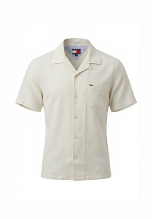 Camisa beige de manga corta con botones, con cuello y bolsillo en el pecho, con un pequeño logo de Tommy Jeans en el bolsillo.