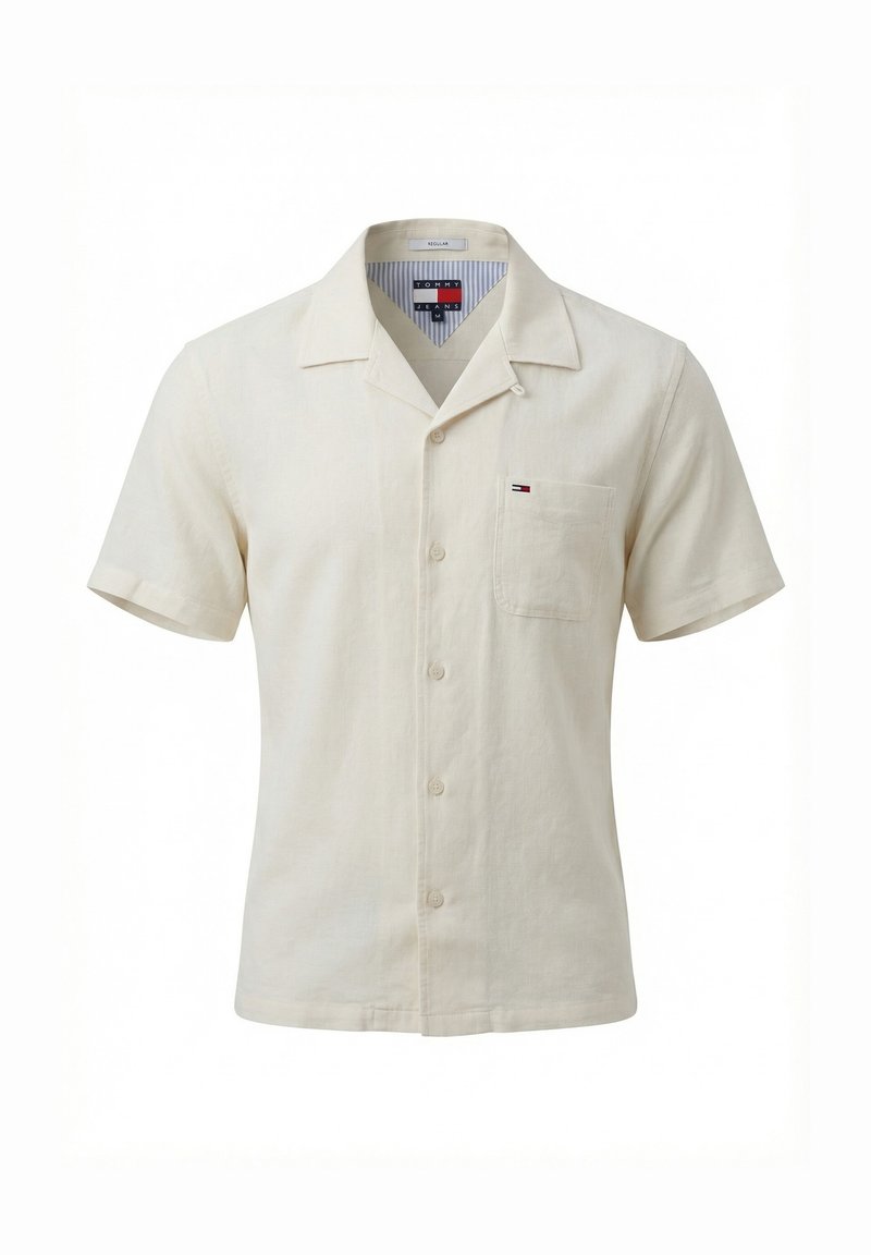 Chemise beige à manches courtes avec boutons, col et poche poitrine, avec un petit logo Tommy Jeans sur la poche.