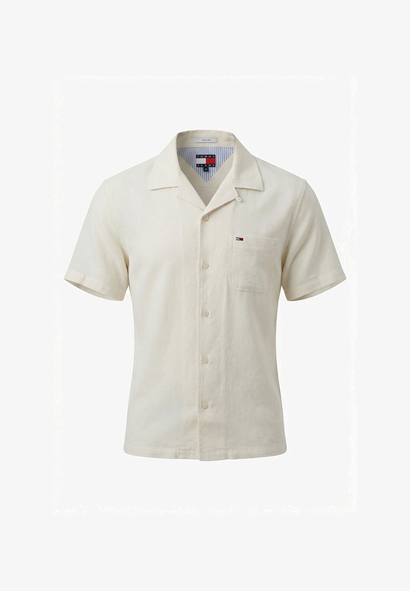Chemise beige à manches courtes avec boutons, col et poche poitrine, avec un petit logo Tommy Jeans sur la poche.