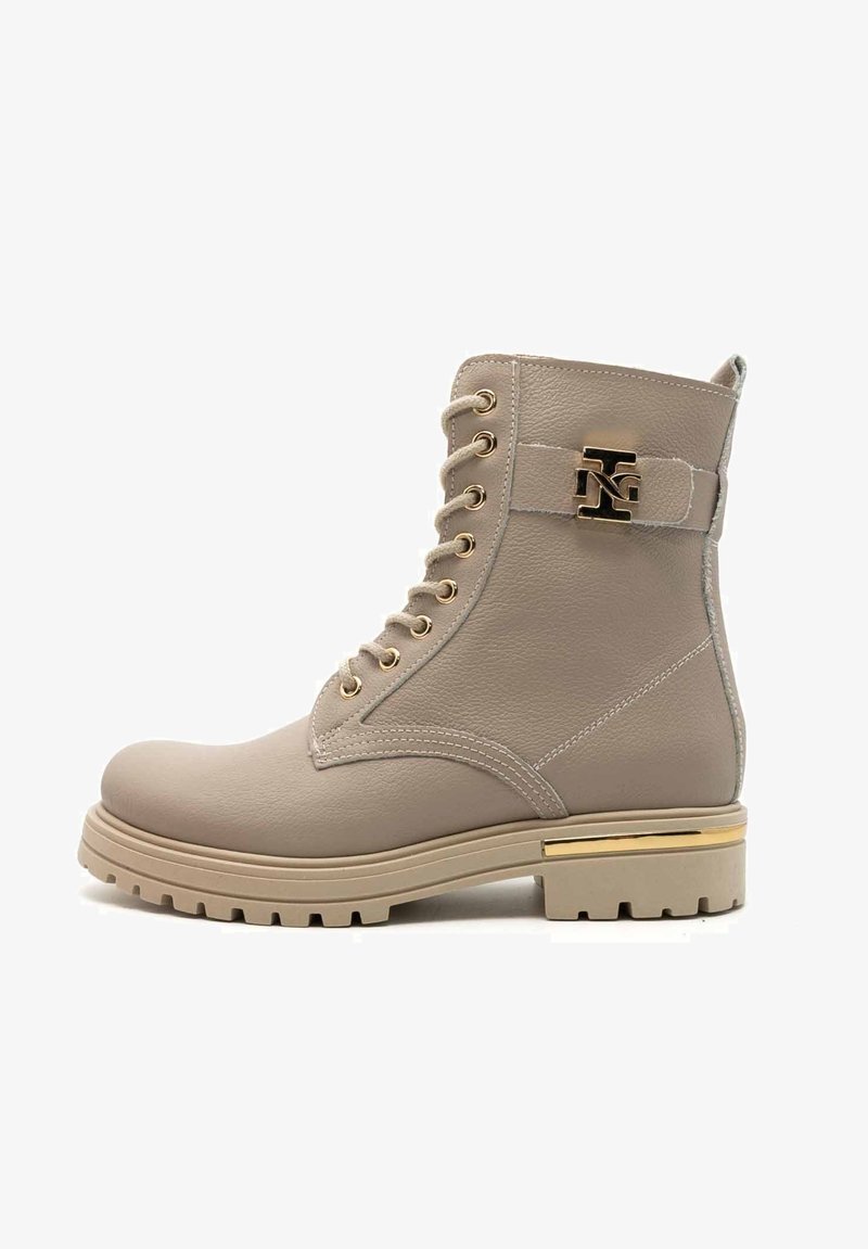 Bottine beige à lacets avec des accents en métal doré, une semelle robuste et du cuir texturé. Présente un détail de logo sur la sangle.