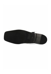 Suela de zapato negra con textura suave, forma redondeada y parte inferior de goma para mayor agarre. Nombre de la marca grabado cerca del talón.