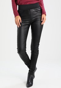 Svarta faux läderbyxor med hög, elastisk midja, slim fit och slät yta, matchade med svarta ankelstövlar.