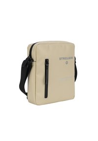 Borsa a tracolla beige con una texture liscia, zip nera, tracolla regolabile e logo stampato. Design rettangolare compatto con una tasca frontale.