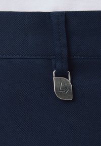 Granatowy materiałowy pas z metalową metką. Teksturowana powierzchnia, płaski design, z widocznym mechanizmem zapięcia.