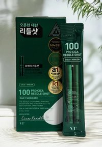 Grön förpackning för en hudvårdsprodukt med en tub med en mörkgrön kork, etiketter med vit och guldig text som framhäver nyckelfunktioner och användning.