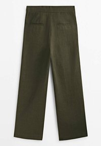 Pantalons larges en vert olive, en tissu texturé, avec deux poches arrière et une taille plate. Présente des coutures décoratives sur les poches.