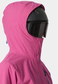 Pink Kapuzenjacke mit hohem Kragen, aus glattem, wasserabweisendem Material. Ausgestattet mit einem schwarzen Skihelm und einer Skibrille. Minimalistisches Design.